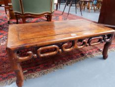 A CARVED CHINESE LOW TABLE OF RECTANGULAR FORM WITH PIERCED SCROLLWORK APRON. H.28 W.76cms.