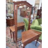 AN INLAID MAHOGANY HOWARD & SONS CHEVAL MIRROR WITH ARCHED PLATE AND SABRE LEGS. H.182 x W.80cms.