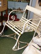 A VICTORIAN WROUGHT IRON GARDEN ROCKING CHAIR TOGETHER WITH A LATER CAST METAL LOW TABLE.