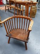 AN ANTIQUE ASH AND ELM PRIMITIVE COMB BACK ARMCHAIR WITH RAISED CREST RAIL.