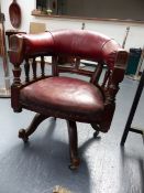 A CARVED WALNUT LATE VICTORIAN REVOLVING TUB FORM ARMCHAIR ON TURNED SPINDLE SUPPORTS WITH