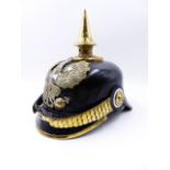 A GERMAN PICKLHAUBE HELMET WITH BLACK LEATHER AND SPIKE FINIAL AND A SILVER CROSS CENTRED HELMET