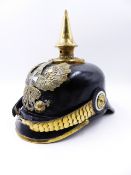 A GERMAN PICKLHAUBE HELMET WITH BLACK LEATHER AND SPIKE FINIAL AND A SILVER CROSS CENTRED HELMET