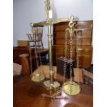 A LARGE SET OF BRASS SHOP BEAM SCALES WITH BULL'S HEAD FINIALS, TWIN PANS AND SHAPED BASE WITH