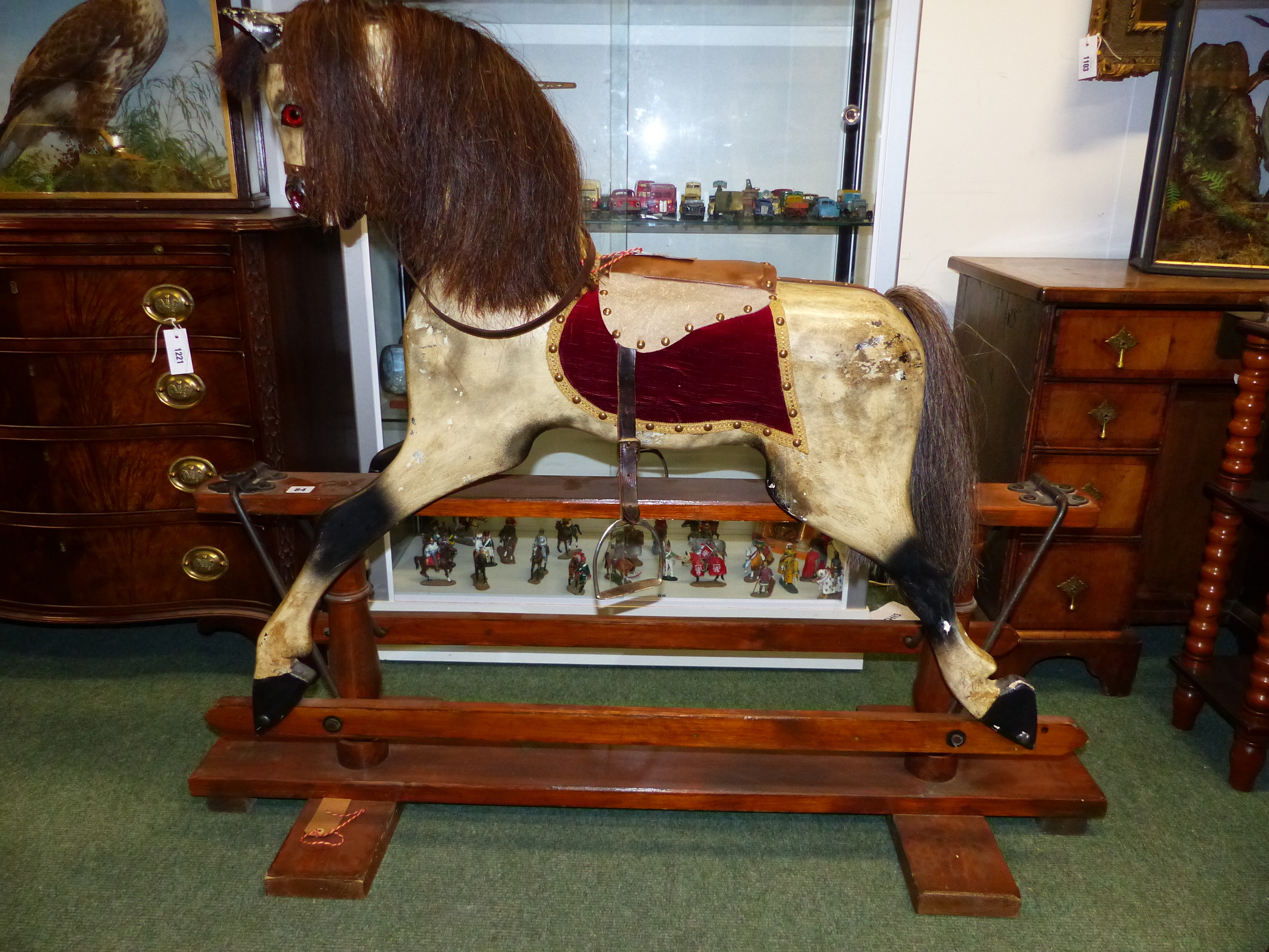 AN EARLY 20th.C.CARVED WOOD AND PAINTED ROCKING HORSE ON TRESTLE BASE. 91cms (HOOF TO EAR)