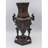 A CHINESE BRONZE VASE OF HEXAGONAL FORM WITH TWIN HANDLES AND ARCHAISTIC ANIMAL FORM SUPPORTS.