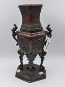 A CHINESE BRONZE VASE OF HEXAGONAL FORM WITH TWIN HANDLES AND ARCHAISTIC ANIMAL FORM SUPPORTS.