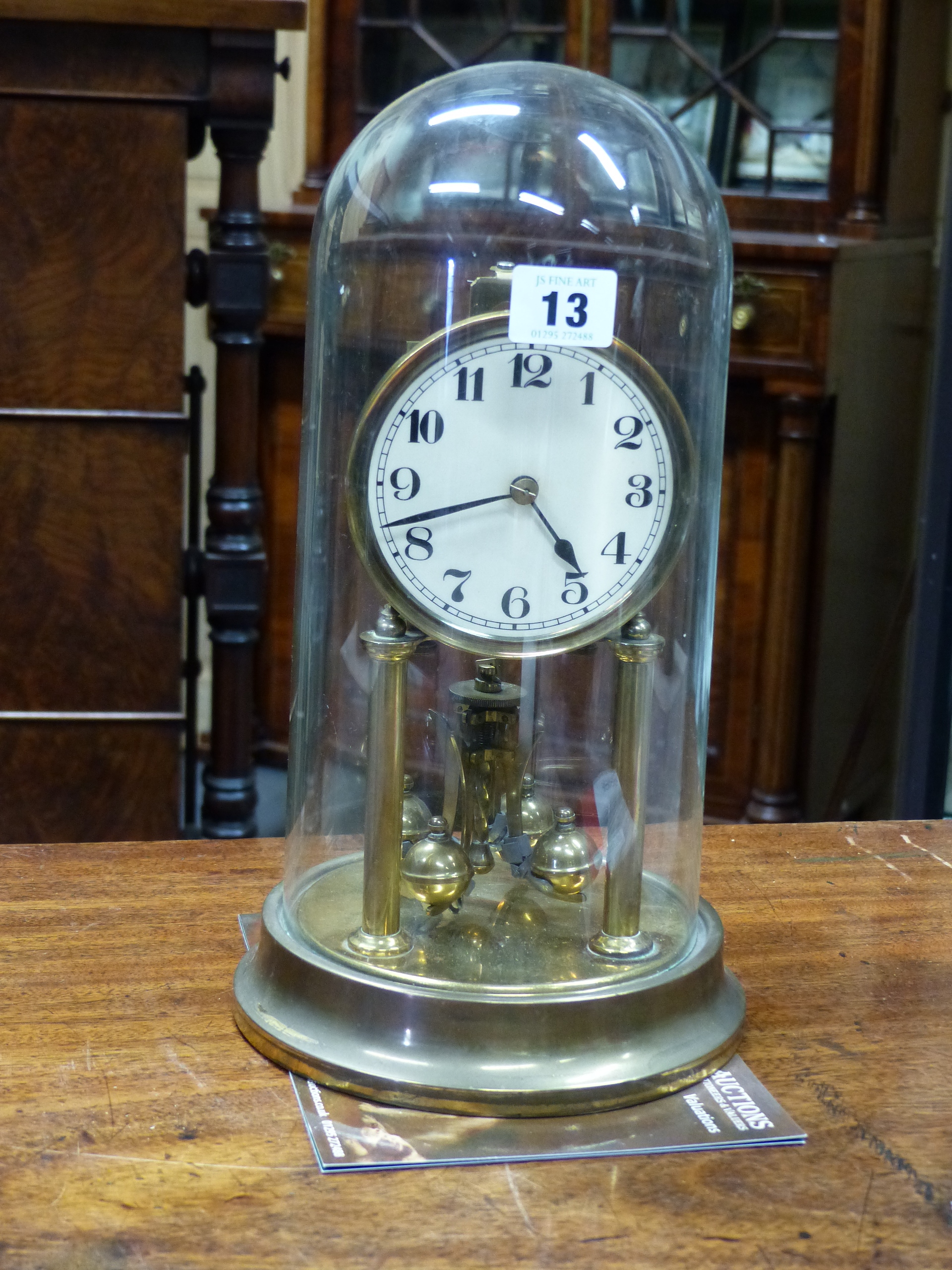 AN EARLY 20th.C.ANNIVERSARY CLOCK UNDER GLASS DOME. H.33cms.