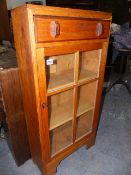 A SMALL COTSWOLD SCHOOL ARTS AND CRAFTS OAK GLAZED BOOKCASE. W.51 x H.104cms.