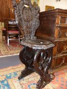 A 19th.C.ITALIANATE CARVED WALNUT HALL CHAIR WITH DOLPHIN FORM SUPPORTS AND CARVED FIGURAL BACK.