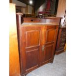 AN ARTS AND CRAFTS LIBERTY STYLE OAK CABINET WITH TWIN PANELLED DOORS AND RAISED PIERCED GALLERY.