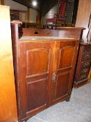 AN ARTS AND CRAFTS LIBERTY STYLE OAK CABINET WITH TWIN PANELLED DOORS AND RAISED PIERCED GALLERY.