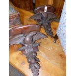 A PAIR OF VICTORIAN CARVED OAK WALL BRACKETS WITH SHAPED TOPS ABOVE SPREAD WINGED EAGLES AND