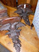 A PAIR OF VICTORIAN CARVED OAK WALL BRACKETS WITH SHAPED TOPS ABOVE SPREAD WINGED EAGLES AND