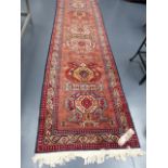 AN ORIENTAL RUNNER OF CAUCASIAN DESIGN. 315x90cms.