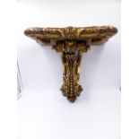 AN ANTIQUE CARVED GILTWOOD WALL BRACKET IN THE GEORGIAN TASTE WITH PIERCED LEAFY SCROLL SUPPORT