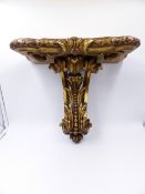 AN ANTIQUE CARVED GILTWOOD WALL BRACKET IN THE GEORGIAN TASTE WITH PIERCED LEAFY SCROLL SUPPORT