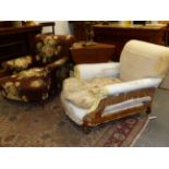 A PAIR OF ANTIQUE HOWARD & SONS UPHOLSTERED CLUB DEEP SEAT ARMCHAIRS, ALL BRASS CASTORS STAMPED
