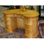 A MID VICTORIAN SATINBIRCH KIDNEY FORM DESK WITH INSET TOOLED LEATHER TOP ABOVE THREE APRON DRAWERS,