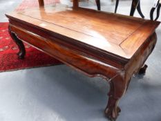 A CHINESE CARVED HARDWOOD LOW TABLE OF RECTANGULAR FORM WITH SHAPED APRON AND BALL AND CLAW FEET.