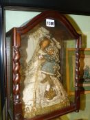 AN ANTIQUE CONTINENTAL CARVED AND GLAZED CASE CONTAINING A WAX HEAD FIGURAL GROUP OF A MOTHER AND