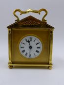 A SMALL EARLY 20th.C.BRASS CASED CARRIAGE CLOCK WITH TWIN ESCARPMENT WINDOW TO PEDIMENT TOP,