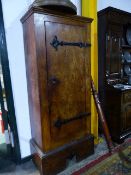 AN ARTS AND CRAFTS ELM HALL CABINET WITH WROUGHT IRON HINGES TO SINGLE PLANK DOOR ENCLOSING SHELVES.