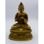 AN ORIENTAL GILT BRONZE FIGURE OF BUDDHA ON LOTUS FORM BASE WITH CHARACTER INSCRIPTION. H.18cms.