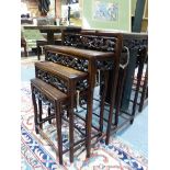 A NEST OF FOUR CHINESE CARVED HARDWOOD TABLES WITH PIERCED FOLIATE APRONS.