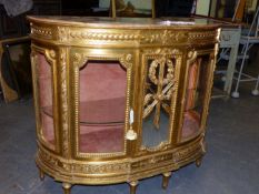 A FRENCH CARVED GILTWOOD BOW FRONT MARBLE TOP DISPLAY CABINET THE CENTRAL MIRROR PANEL DECORATED