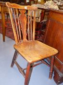 AN EARLY COUNTRY ELM SEAT SIDE CHAIR WITH SPINDLE BACK AND SHAPED CREST RAIL.