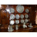 TWELVE ANTIQUE PEWTER PLATES. TOGETHER WITH A CHARGER AND VARIOUS MEASURES.