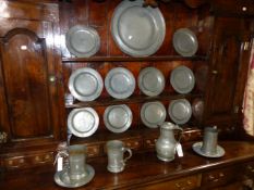 TWELVE ANTIQUE PEWTER PLATES. TOGETHER WITH A CHARGER AND VARIOUS MEASURES.