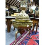 A PERSIAN BRASS BRAZIER WITH PIERCED DOME COVER, FLANKING CARRYING HANDLES AND SCROLL LEGS. H.