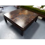 AN ORIENTAL GILT AND EBONISED SQUARE LOW TABLE WITH LANDSCAPE DECORATION TO THE TOP. H.38 W.101cms.
