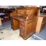 AN EARLY 20th.C.OAK ROLL TOP DESK WITH S ROLL TAMBOUR AND PIGEONHOLE INTERIOR. W.127cms.