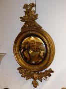 A LARGE REGENCY CARVED GILTWOOD CONVEX MIRROR WITH ENTWINED DOLPHIN CREST. H.128cms.