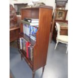 A MAHOGANY REGENCY STYLE WATERFALL BOOKCASE WITH BASE DRAWER ON REEDED TAPERED LEGS. H.121 x D.