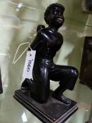 A CARVED AND EBONISED FIGURE OF A KNEELING BLACKAMOOR CARRYING AN URN/HOLDER. H.27cms.