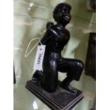 A CARVED AND EBONISED FIGURE OF A KNEELING BLACKAMOOR CARRYING AN URN/HOLDER. H.27cms.