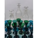 A GROUP OF NINETEEN EMERALD GREEN WINE GLASSES OF VARYING SIZES AND THREE LARGE DECANTERS.