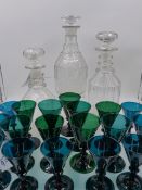 A GROUP OF NINETEEN EMERALD GREEN WINE GLASSES OF VARYING SIZES AND THREE LARGE DECANTERS.