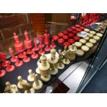 THREE ANTIQUE CARVED AND STAINED IVORY AND BONE BOARD GAME PIECES, TWO CHESS SETS AND A SET OF
