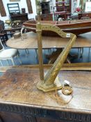 A CARVED GILTWOOD TABLE LAMP IN THE FORM OF A HARP. H.73cms.