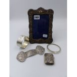 A HALLMARKED SILVER PHOTO FRAME, A WHITE METAL BUCKLE, SILVER VESTA CASE AND TWO SILVER BANGLES.