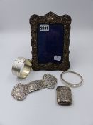 A HALLMARKED SILVER PHOTO FRAME, A WHITE METAL BUCKLE, SILVER VESTA CASE AND TWO SILVER BANGLES.