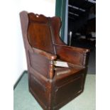 AN 18th.C.AND LATER PANELLED OAK WINGBACK LAMBING ARMCHAIR WITH BOX SEAT.