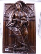 AN EARLY CARVED OAK PANEL OF A CLASSICALLY DRAPED LADY HOLDING A CHILD IN AN ARCHITECTURAL NICHE.