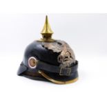 A GERMAN PICKLEHAUBE HELMET WITH BLACK LEATHER SKULL AND SPIKE FINIAL AND WINGED GRIFFIN HELMET