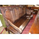 AN 18th.C.AND LATER OAK HALL SETTLE WITH FIVE PANEL BACK AND PLANK SEAT. W.183cms.
